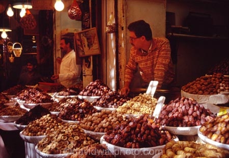 africa;african;africans;north-africa;moroccan;shop;shops;stall;stalls;market;markets;piles;display;displayed;travel;morocco;north-africa;produce;food;basin;basins;dried-fruit;fruit;fruits;nut;nuts;dates;walnuts;banana;vendor;man;seller;shopkeeper