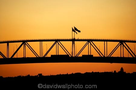Auckland;Auckland-Harbour-Bridge;bridge;bridges;dusk;evening;flag;flags;N.I.;N.Z.;New-Zealand;NI;nightfall;North-Island;NZ;orange;silhouette;silhouettes;sky;span;spans;steel;structure;structures;sunset;sunsets;transport;transportation;twilight