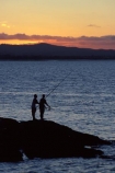 coast;dusk;fish;fisher;fisherman;fishermen;fisherwoman;harbor;harbors;harbour;harbours;relaxing;rod;sunset;water