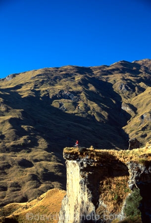 Queenstown;Central-Otago;Skippers-Canyon;canyon;mountain-biker;mountain-bike;mountain;mountains;rocks;rocky;rock;grassy;sky;blue;clear;adventure;green;distant;cliff;shadow;shadowy