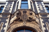 statue;entrance;ornate;ornamentation;motto;crest;latin