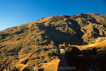 Queenstown;Central-Otago;Skippers-Canyon;canyon;mountain-biker;mountain-bike;mountain;mountains;rocks;rock;rocky;shadow;shadows;shadowy;sky;blue;clear-sky;auburn;brown;grassy;distant;distance