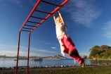 action;activity;caucasian;child;Child-Playing;childhood;children;excercise;excercising;fun;girl;girls;gymnastics;hang;hanging;jungle-gym;Karitane;Monkey-Bars;New-Zealand;Otago;outdoors;park;parks;people;person;play;playground;playgrounds;playing;plays;recreation-leisure;South-Island;swing;swinging;young